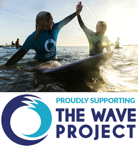 Wave Project logo and a happy image of two girls hi-fiving in water on surfboards.